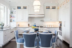 Синие стулья в интерьере белой кухни
