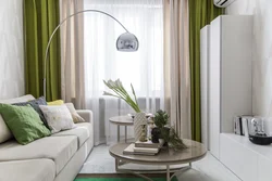 Шторы в сером интерьере гостиной с зеленым диваном
