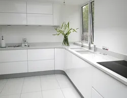 Белая кухня с серой столешницей и фартуком в интерьере фото