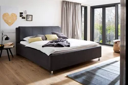 Gray soft bed in the bedroom interior