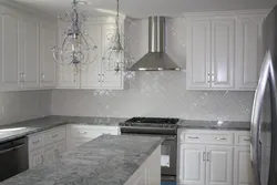 Kitchen with a gray countertop in a white interior and an apron