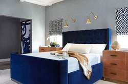 Мягкая синяя кровать в интерьере спальни