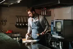 Мужчына гатуе на кухні фота