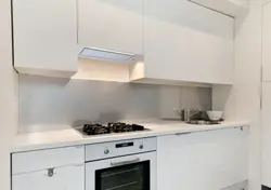 Photo of a beige kitchen with a hood