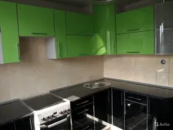 Green kitchen with black countertop photo