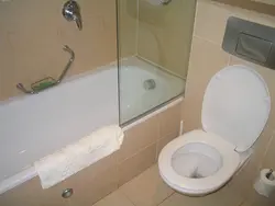 Toilet between bathtub and sink photo