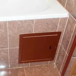 Hatch under the bathtub under the tiles photo