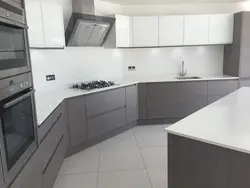 Photo of white kitchen with gray appliances