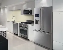 Photo of white kitchen with gray appliances