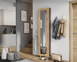 Coat rack in a small hallway with a mirror photo