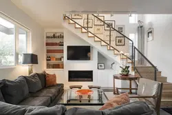Photo of the living room interior with a fireplace and staircase