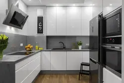 Чорны халадзільнік на белай кухні ў інтэр'еры фота