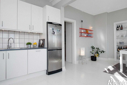 Black refrigerator in a white kitchen in the interior photo