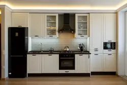 Black refrigerator in a white kitchen in the interior photo