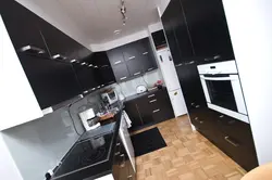 Black refrigerator in a white kitchen in the interior photo