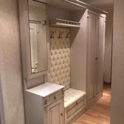 Wardrobe in the hallway with a mirror and a shoe rack, a hanger and a seat photo