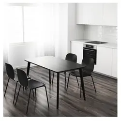 Table with black legs in the kitchen interior