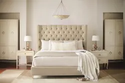 Beige bed with a soft headboard in the bedroom interior
