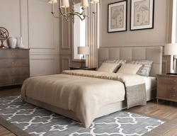 Beige bed with a soft headboard in the bedroom interior