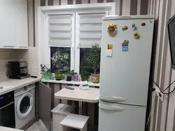 Kitchen design with a refrigerator by the window and a gas stove