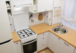 Kitchen design with a refrigerator by the window and a gas stove