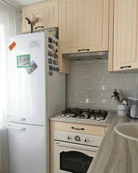 Kitchen design with a refrigerator by the window and a gas stove