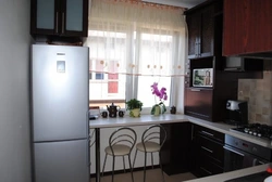 Дизайн кухни с холодильником у окна и газовой плитой