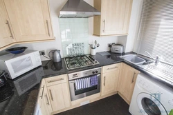 Kitchen design with a refrigerator by the window and a gas stove