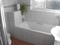 Photo of the bathtub covered with tiles