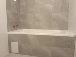 Photo of the bathtub covered with tiles