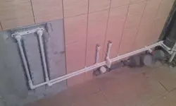 Photo of bathtub tiles and pipes