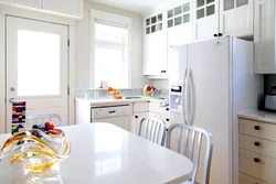 Photo of a kitchen with a refrigerator and a table