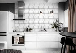 Белая кухня на черном кафеле фото