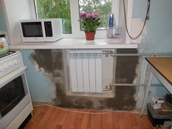 Refrigerator Near The Radiator In The Kitchen Photo