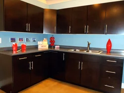 Black kitchen with brown countertop photo