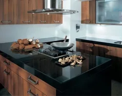 Чорная кухня з карычневай стальніцай фота