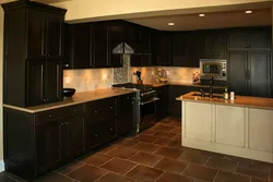 Black kitchen with brown countertop photo
