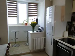 Холодильник у балконной двери на кухне фото