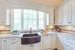 White kitchen with sink by the window photo