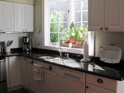 White kitchen with sink by the window photo