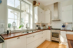 White kitchen with sink by the window photo