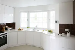 Белая кухня з мыйкай каля акна фота