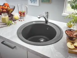 Black sink and faucet in the kitchen photo