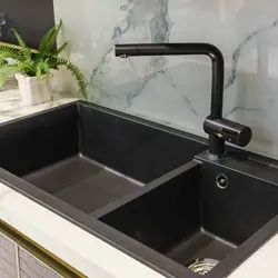 Black sink and faucet in the kitchen photo