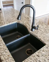 Black sink and faucet in the kitchen photo