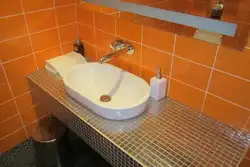 Hammom fotosuratida gipsokartadan tayyorlangan lavabo ostidagi stol usti