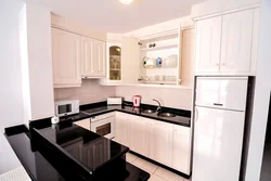White Kitchen With Black Countertop And Bar Counter Photo