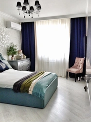 Curtains in the interior of a bedroom with a blue bed