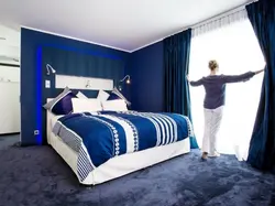 Curtains In The Interior Of A Bedroom With A Blue Bed