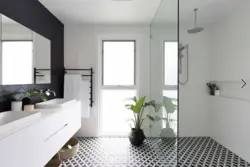 Black shower cabin in the interior of a white bath